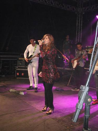 Vocalista de vestido sob iluminação violeta